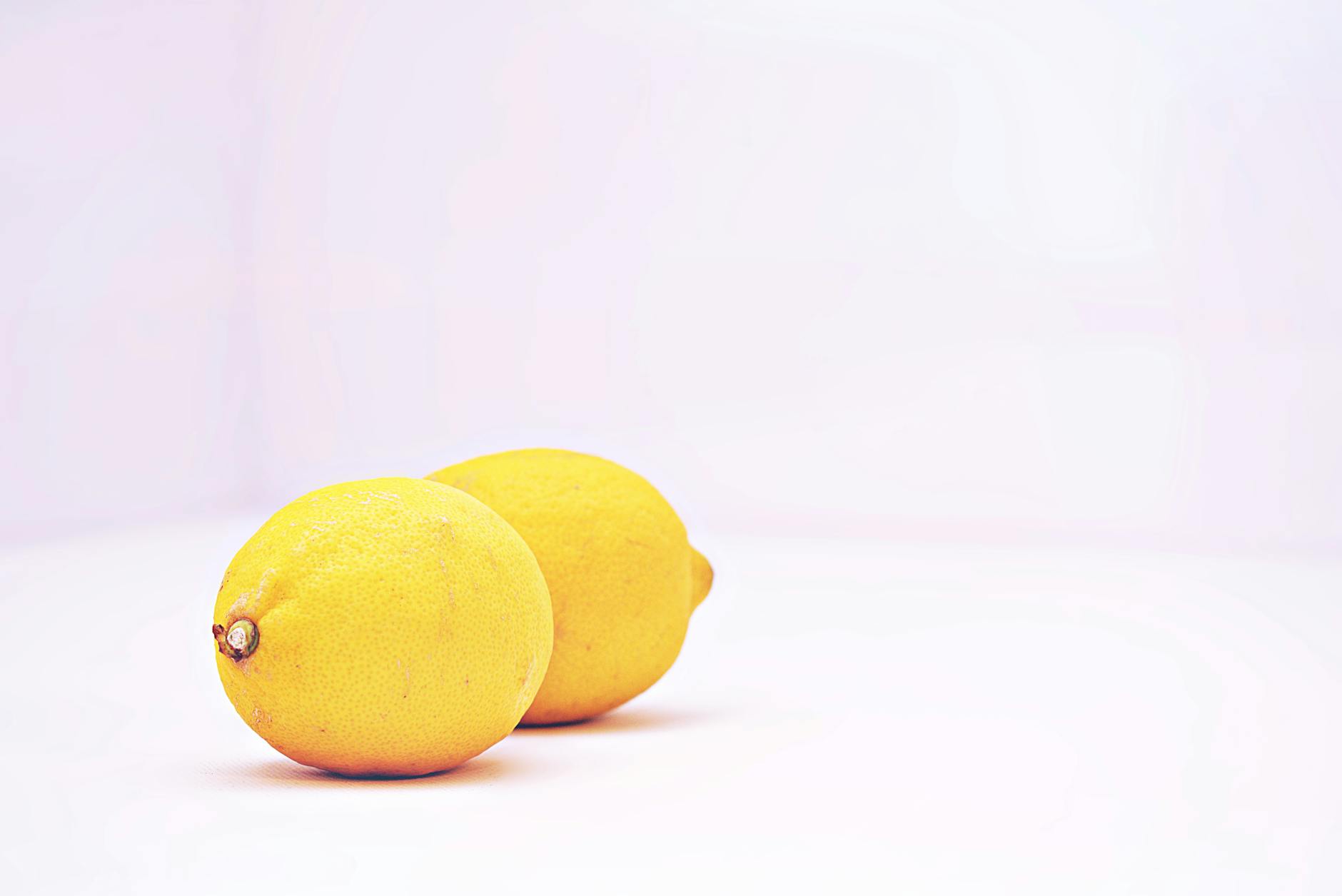 Fresh lemons on a clean white background, representing hormonal cycles and natural sensitivity shifts