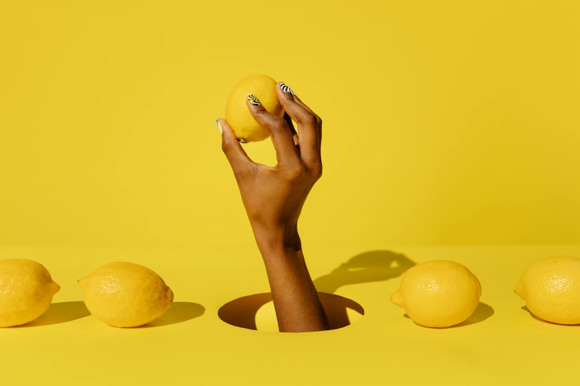 Fresh lemons arranged on a pastel green background, representing the bright, accessible approach to pleasure through The Lem Massager.
