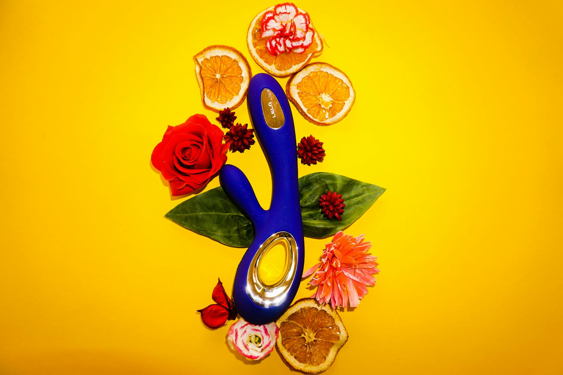 A blue silicone lemon vibrator held confidently in hand against a purple background