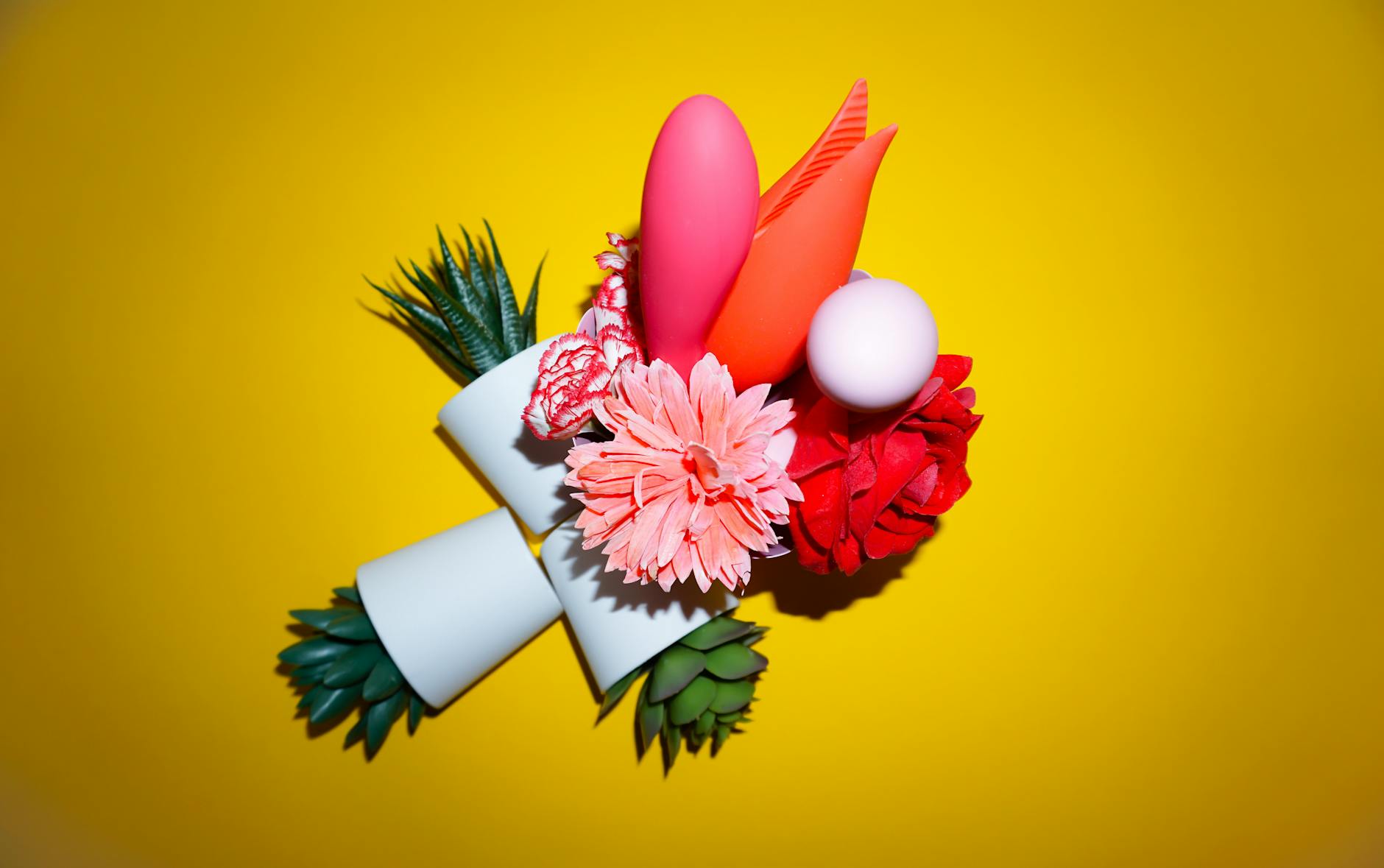 Two people holding colorful vibrators together, showing partnership and shared exploration